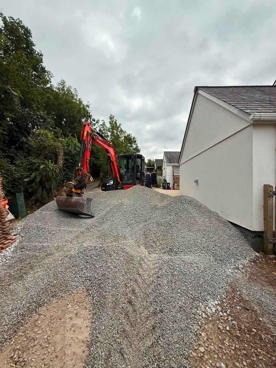 Aggregate delivered beside an excavator ready for site work